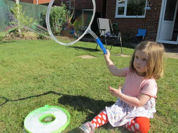 Girl blowing bubbles with a wand