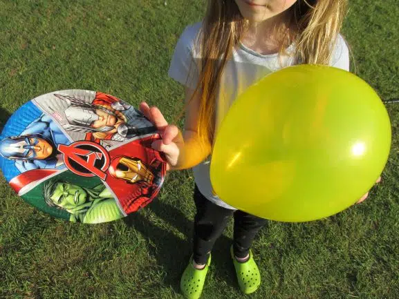 Child holding balloon and paper plate