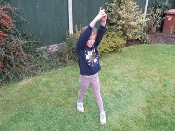 Young girl doing a giraffe yoga pose