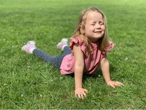 A young girl doing a seal yoga pose