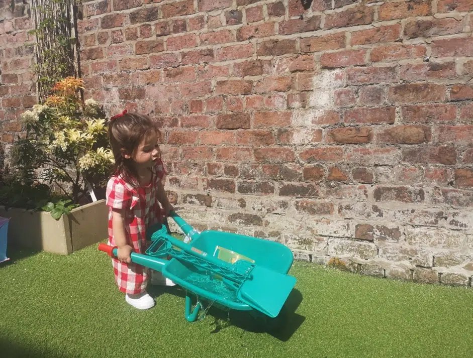 Girl using a wheelbarrow as a transporting schema