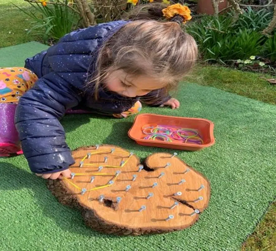 Child displaying positioning schema using geoboard