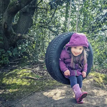 Girl swinging in a tire swing