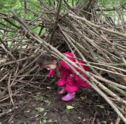 A girl hiding in a stick den
