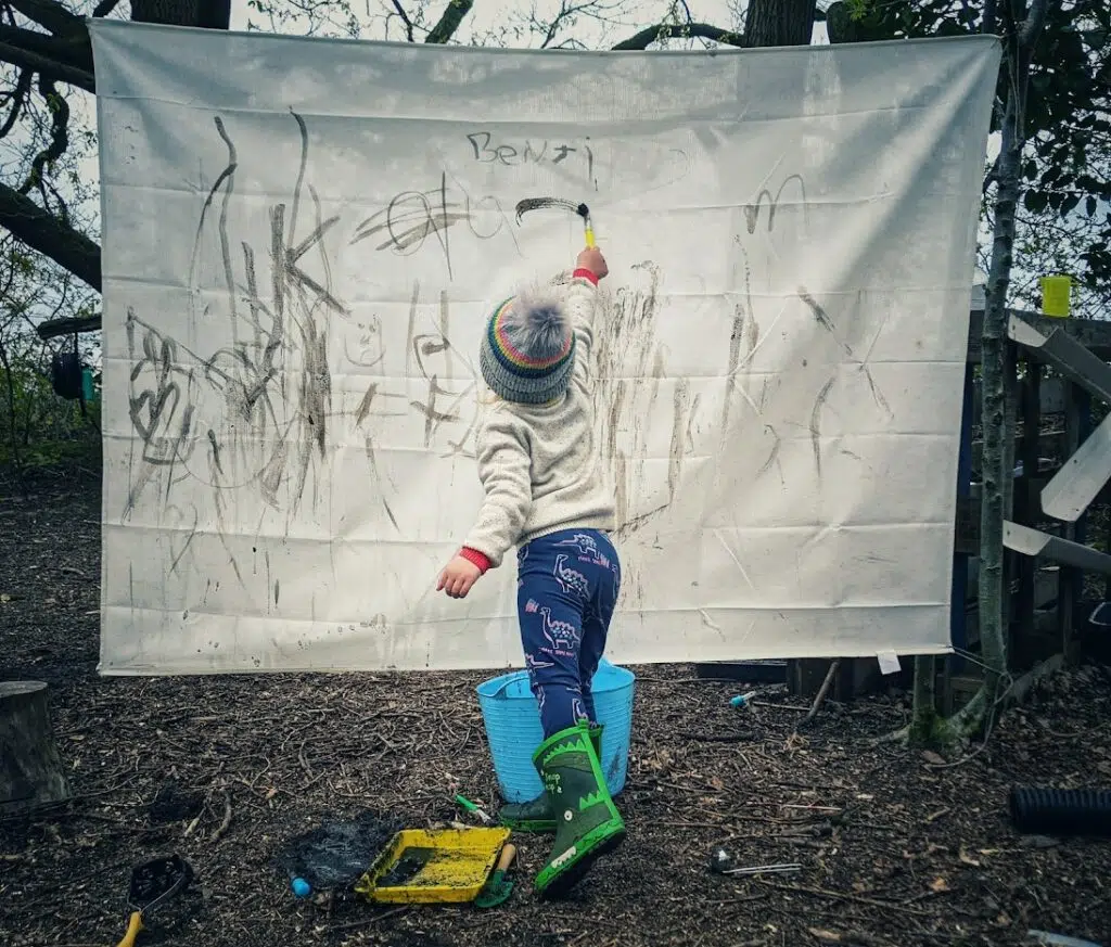 Writing with mud on a big sheet