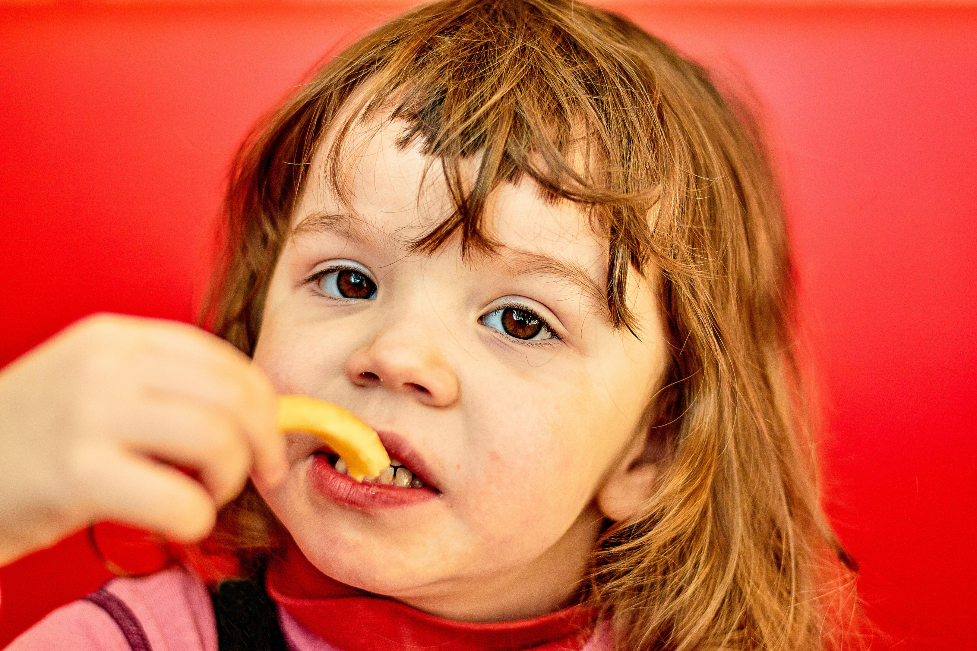  close-up shot of a child eating french fries