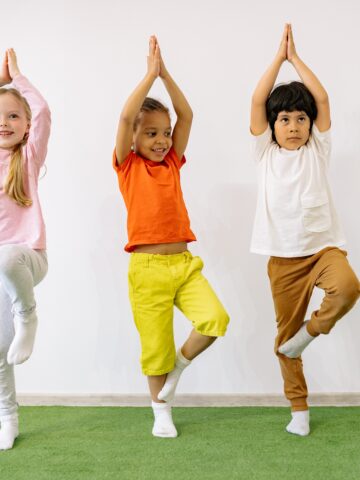 children doing kids yoga and balancing